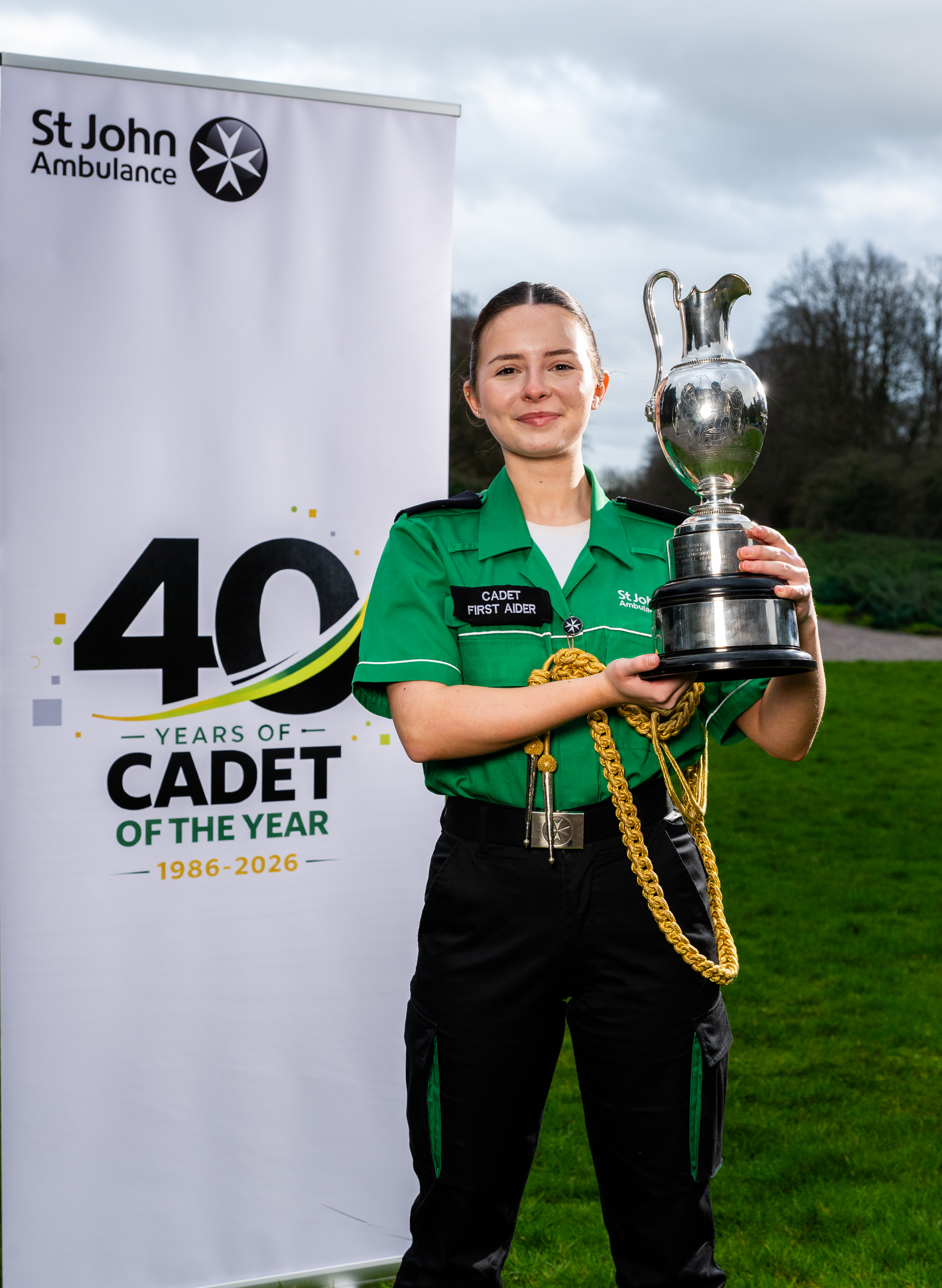 Emily England NCOTY trophy outside smiling 40 anniversary banner - portrait.jpg