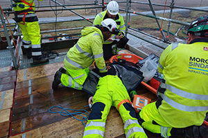 A construction worker performing CPR on his colleague.