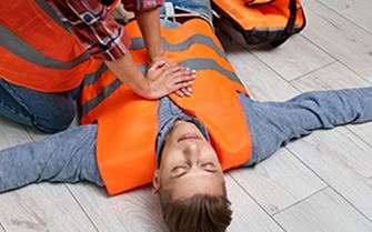 A first responder providing first aid care for a casualty.