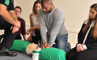 A group of first aid students learning about CPR.