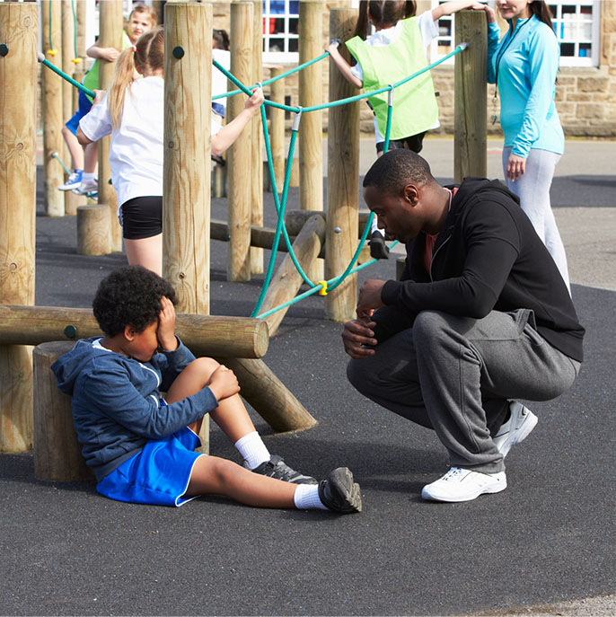 A teacher coming to the aid of a pupil.