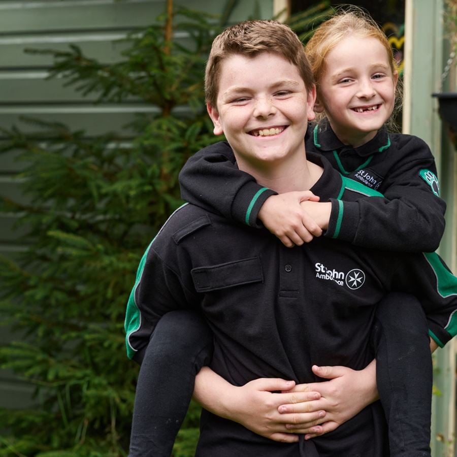 A young Badger girl getting a piggy back from a young Badger boy. 