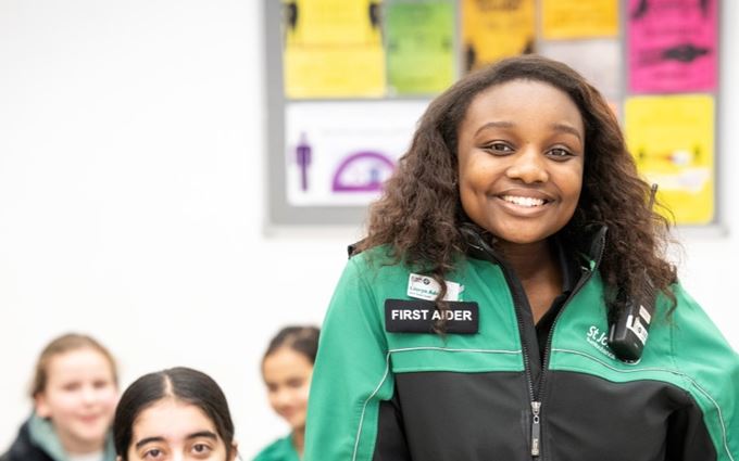 Youth Team volunteer stood in front of a Cadet group smiling.
