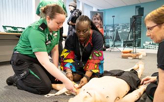 First aid trainer showing how to bandage an arm