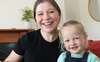 Beth smiling and holding her nephew.