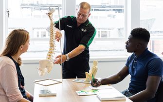 St John Ambulance trainer explaining spinal anatomy to class participants